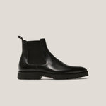 Black Chelsea boot on a light gray background