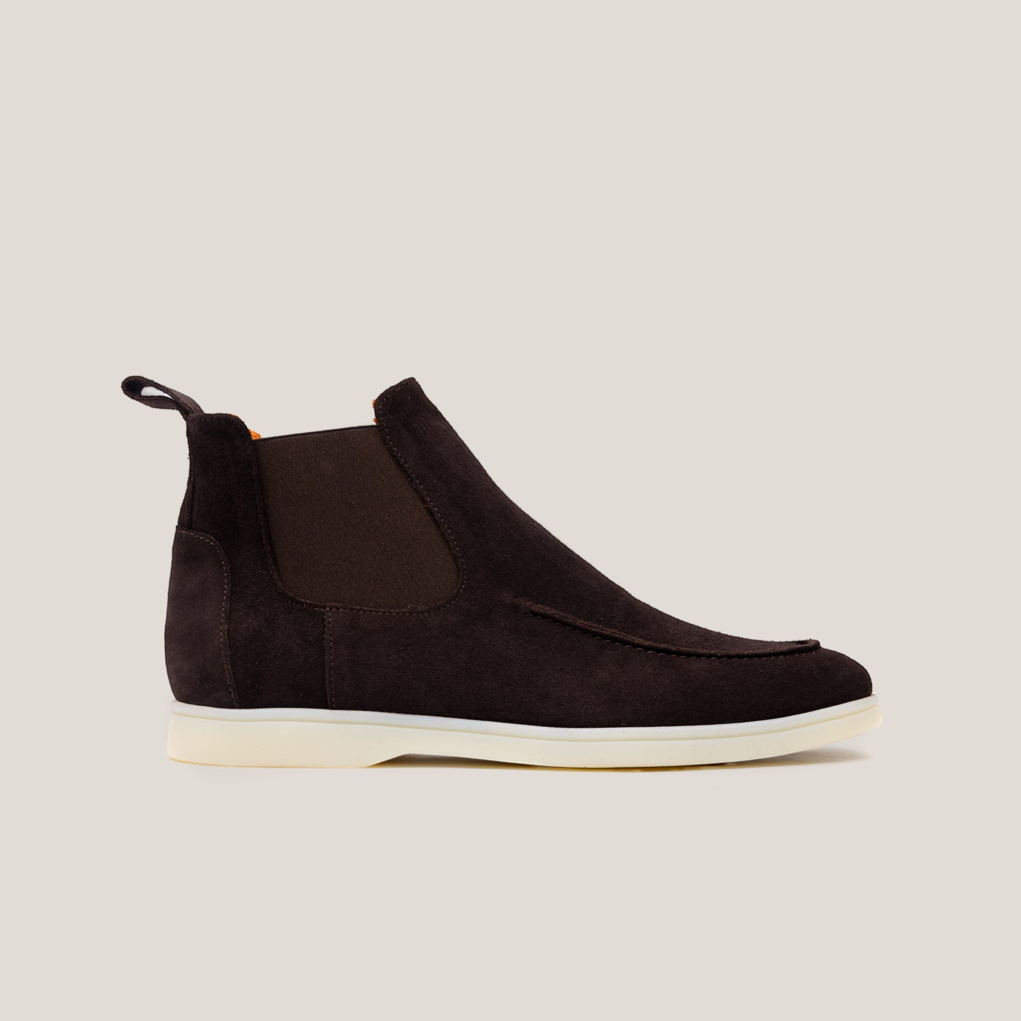 A dark brown suede Chelsea boot with a white sole.