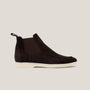 A dark brown suede Chelsea boot with a white sole.