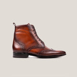 A single cognac brown leather balmoral boot with brogue detailing and a lace-up closure on a white background.